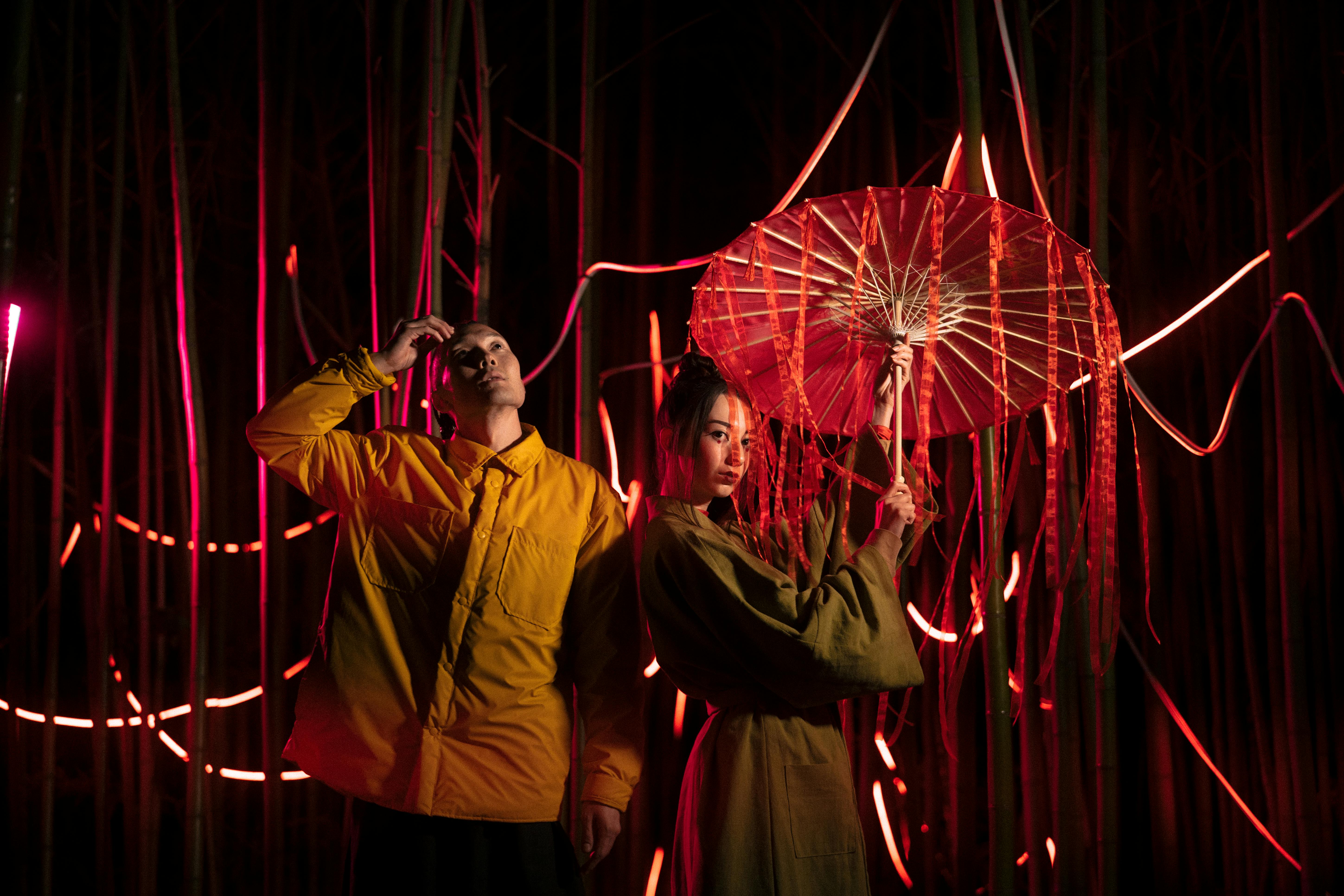 Elegant Japanese couple posing artistically with vibrant lighting effects, embracing traditional aesthetics.